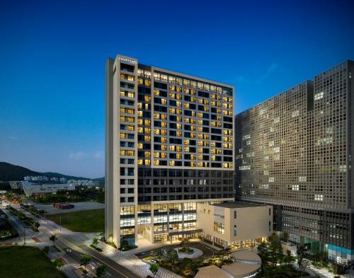 a tall building with lights on in a city at Courtyard by Marriott Sejong in Sejong