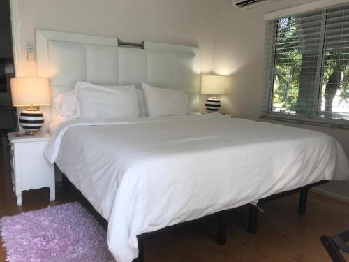 a large white bed in a bedroom with two lamps at Gulfside Resort. Unit 1 in St Pete Beach