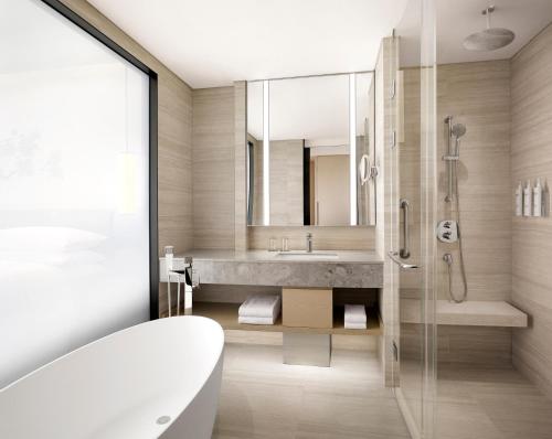 a bathroom with a tub and a sink at Courtyard by Marriott Sejong in Sejong
