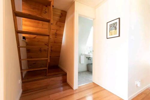 a staircase in a home with wooden floors at Poppies Retreat in Great Bay