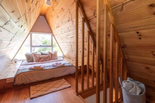 a bedroom with a bed in a wooden cabin at Poppies Retreat in Great Bay