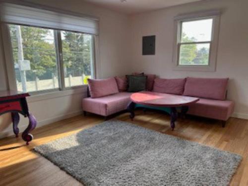 Sala de estar con sofá púrpura y mesa de centro en Relax & Recharge At The Sea, en Long Branch