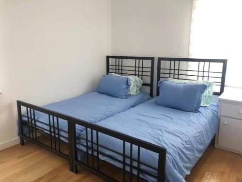 2 camas en una habitación con sábanas y almohadas azules en Relax & Recharge At The Sea, en Long Branch