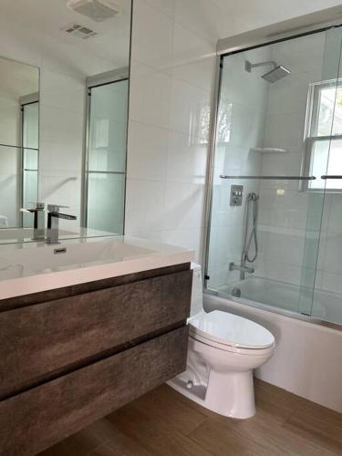 a bathroom with a toilet and a shower and a tub at Relax & Recharge At The Sea in Long Branch