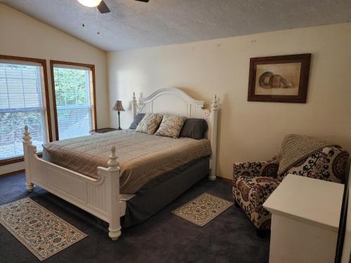 ein Schlafzimmer mit einem Bett, einem Stuhl und einem Fenster in der Unterkunft A Wine Country Home in Yamhill County 
