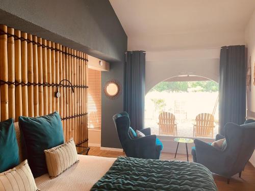 1 dormitorio con cama, sillas y ventana en Echo d'Eau Host & Coach, en La Jaudonnière