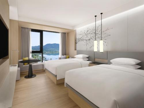 a hotel room with two beds and a window at Courtyard by Marriott Sejong in Sejong