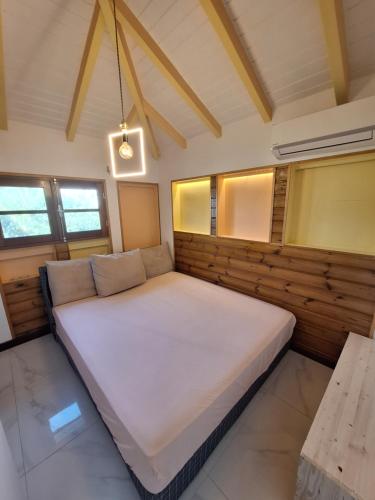 een groot wit bed in een kamer met ramen bij RIVER PARADISE in Goyave