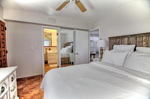 a bedroom with a white bed with a ceiling fan at Gulfside Resort Unit 2 in St. Pete Beach