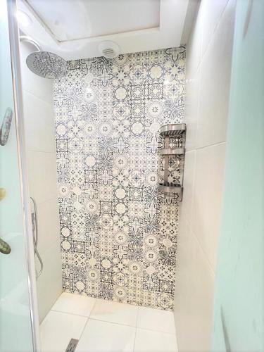 La salle de bains est pourvue d'une douche et d'un mur en carrelage. dans l'établissement Coquet studio pour vacance, à Marrakech