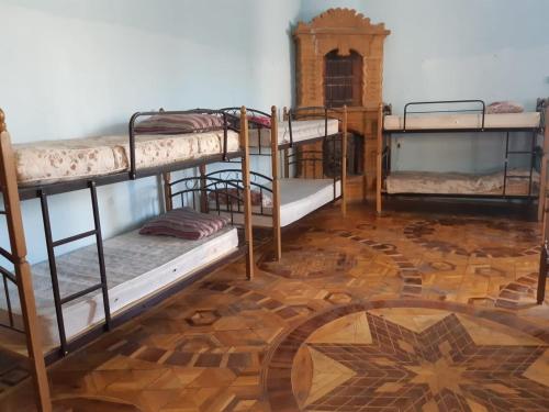 a room with three bunk beds and a wooden floor at BAKU GUEST HOSTEL in Baku