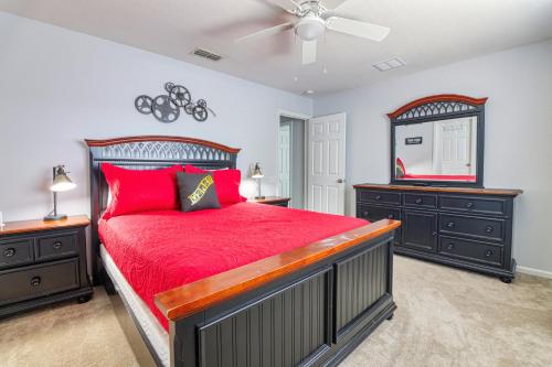 - une chambre avec un lit rouge, 2 commodes et un miroir dans l'établissement Christophers Windsor Hills Home, à Orlando