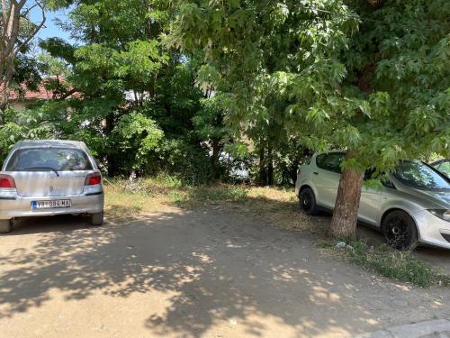 two cars parked next to each other under a tree at Bora Apartmani - FREE PARKING - CITY CENTER in Vranje