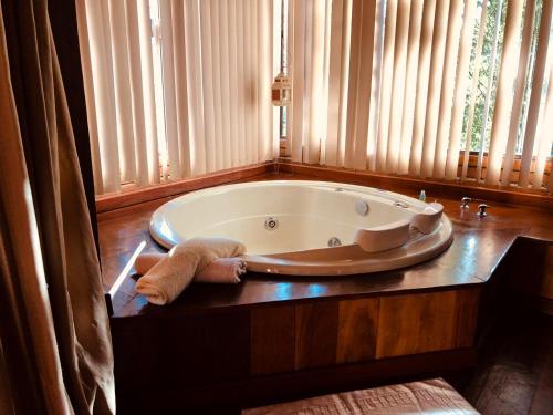 uma banheira sentada numa mesa na casa de banho em Pousada chalés Binitz em Visconde de Mauá