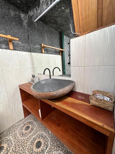 ein Badezimmer mit einem Steinwaschbecken auf einer Holztheke in der Unterkunft Gili Land in Gili Air