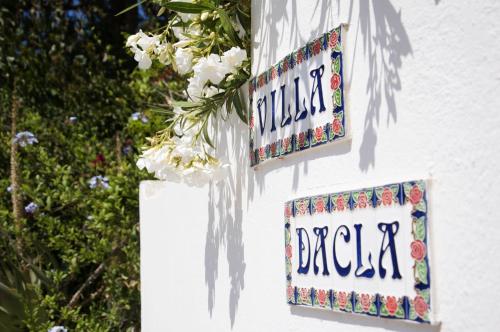 dos letreros en el lado de una casa con flores en Villa Dacla en Lampedusa