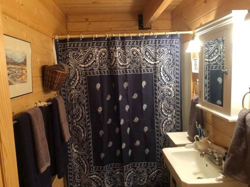 a bathroom with a black shower curtain and a sink at Beautiful Mountain Cabin near Tetons Yellowstone in Dubois
