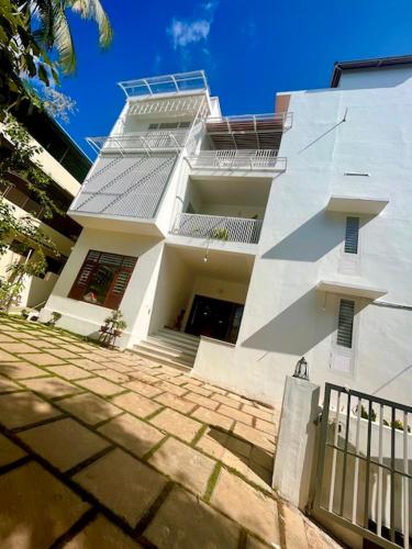 a large white building with a gate in front of it at NIRVANA HAVEN HOME STAY in Trivandrum
