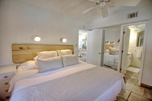 1 dormitorio con 1 cama blanca grande con almohadas blancas en Gulfside Resort. Unit 3, en St Pete Beach