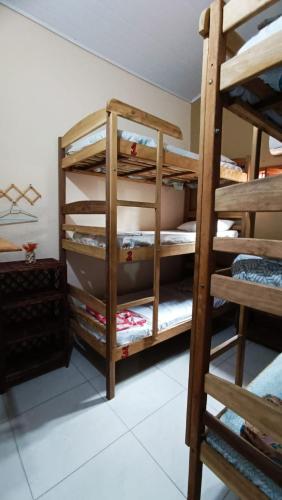 a room with a bunk bed and a bunk room with a ladder at Hostel Alto Astral - Fonte in Morro de São Paulo