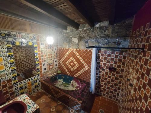 een betegelde badkamer met een bad en een wastafel bij HOTEL RINCÓN MAGICO REAL DE CATORCE in Real de Catorce