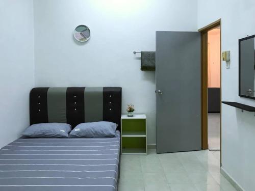a bedroom with a bed with blue pillows and a television at Julia Homestay Taman Tasik Utama MiTC in Melaka