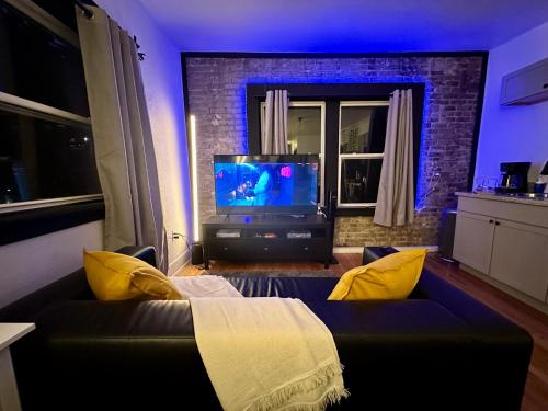 a living room with a couch and a tv at McKinley Beach Sunrise Studio - Pet Friendly in Milwaukee