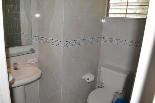 a bathroom with a white toilet and a sink at Casa Playa Tonsupa Tu paraíso frente al mar Internet Alta Velocidad Smart TV Netflix in Tonsupa