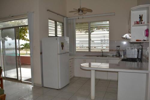 a kitchen with a white refrigerator and a table at Casa frente al mar - Internet - SmartTV - Netflix - DirectTV in Tonsupa