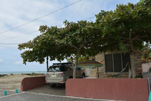 a car parked in front of a house with an umbrella at Casa Playa Tonsupa Tu paraíso frente al mar Internet Alta Velocidad Smart TV Netflix in Tonsupa