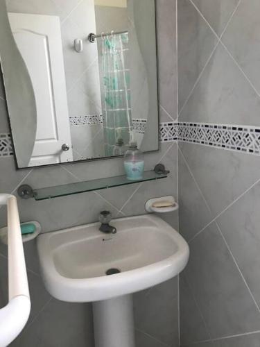 a white bathroom with a sink and a mirror at Casa Playa Tonsupa Tu paraíso frente al mar Internet Alta Velocidad Smart TV Netflix in Tonsupa
