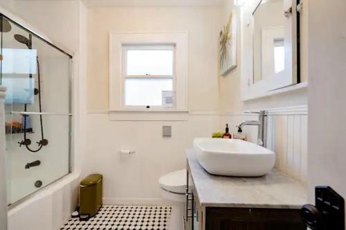 a white bathroom with a sink and a shower at World Solo Travel's Welcomed At St Pete Home in St. Petersburg