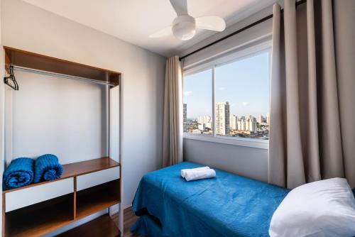a bedroom with a blue bed and a window at 1604 - Apto com piscina Prox Bras e Centro in Sao Paulo