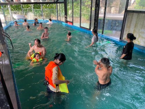un grupo de personas en una piscina en Hoàng Hà Hotel Tam Đảo en Tam Ðảo