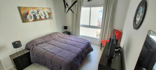 1 dormitorio con cama morada y ventana en Del Barco, Caballito, P. 5° Vista Panorámica en Buenos Aires
