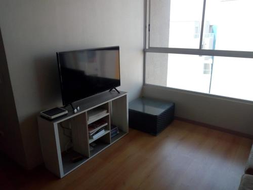 a living room with a flat screen tv on a stand at TUNA HOSTEL in Lima