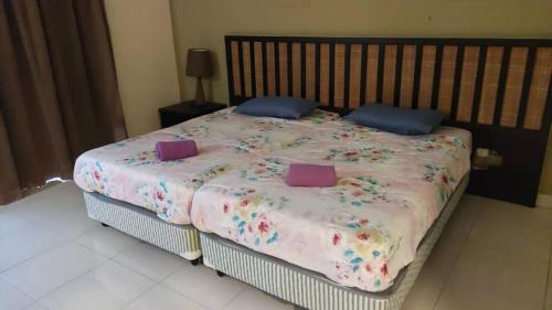 a bedroom with a large bed with purple pillows at Family Homestay in Banting