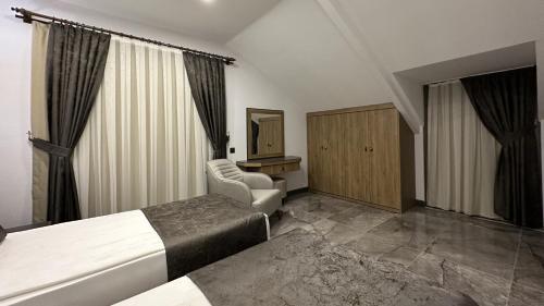 a hotel room with two beds and a chair at Quality Gold Suite Hotel in Antalya