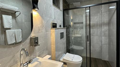 a bathroom with a toilet and a sink and a shower at Quality Gold Suite Hotel in Antalya
