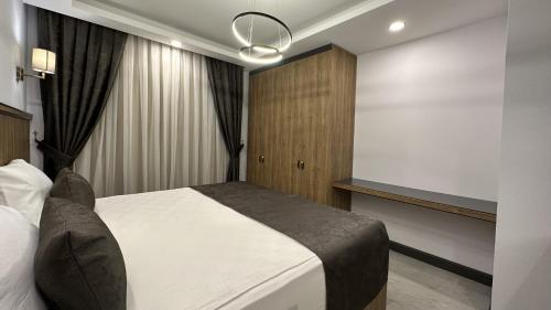 a bedroom with a white bed and a projection screen at Quality Gold Suite Hotel in Antalya