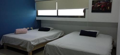 2 camas en una habitación pequeña con ventana en Palma Dorada Country, en Villahermosa