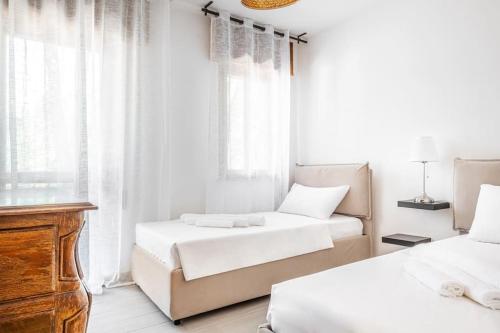 1 Schlafzimmer mit 2 Betten, einer Kommode und Fenstern in der Unterkunft PINETA HOUSE LIGNANO [Free Parking-Beach-Garden] in Lignano Sabbiadoro