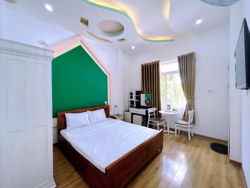 a bedroom with a bed and a green wall at Mai An Homestay in Thôn Trường Giang