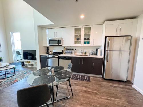 a kitchen with a table and a refrigerator at LUXURY LA PENTHOUSE PRIME LOCATION Min from HOLLYWOOD and DOWNTOWN in Los Angeles