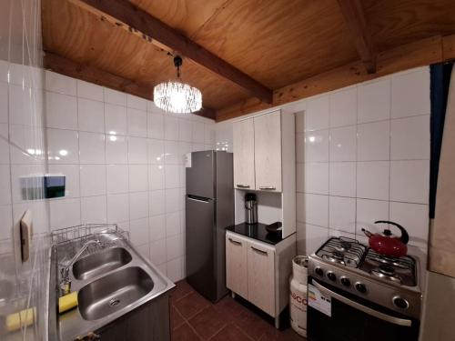 a small kitchen with a stove and a refrigerator at CASA TAMBO in San Pedro de Atacama