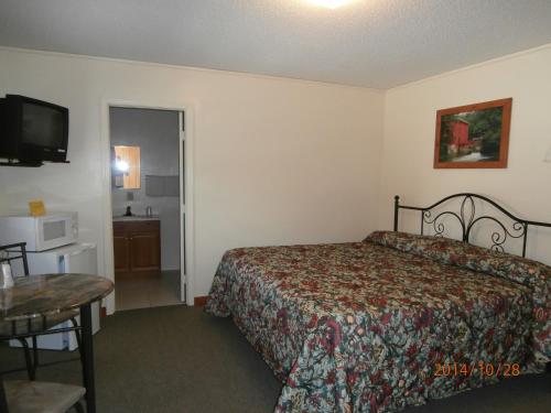 a hotel room with a bed and a television at Riverbend Lodging in Bryson City