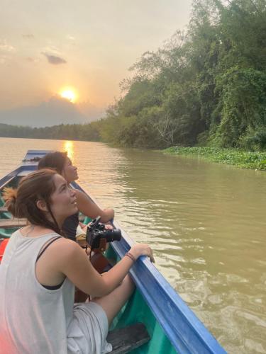 dos mujeres en un barco en un río con una cámara en Cát Tiên Riverside, en Tân Phú