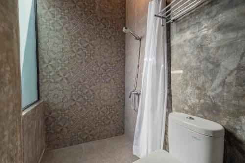 a bathroom with a shower with a toilet and a shower curtain at ME Villa Pererenan in Canggu