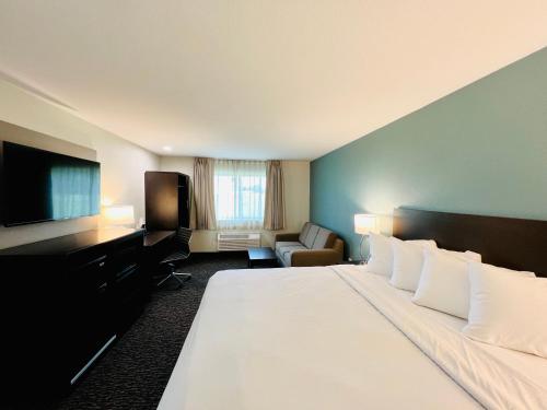 um quarto de hotel com uma cama grande e uma televisão de ecrã plano em Sleep Inn & Suites Lake Delton-Wisconsin Dells Newly Renovated 2024 em Wisconsin Dells