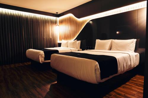 ケレタロにあるHotel Yoruのベッド2台と照明付きのホテルルームです。